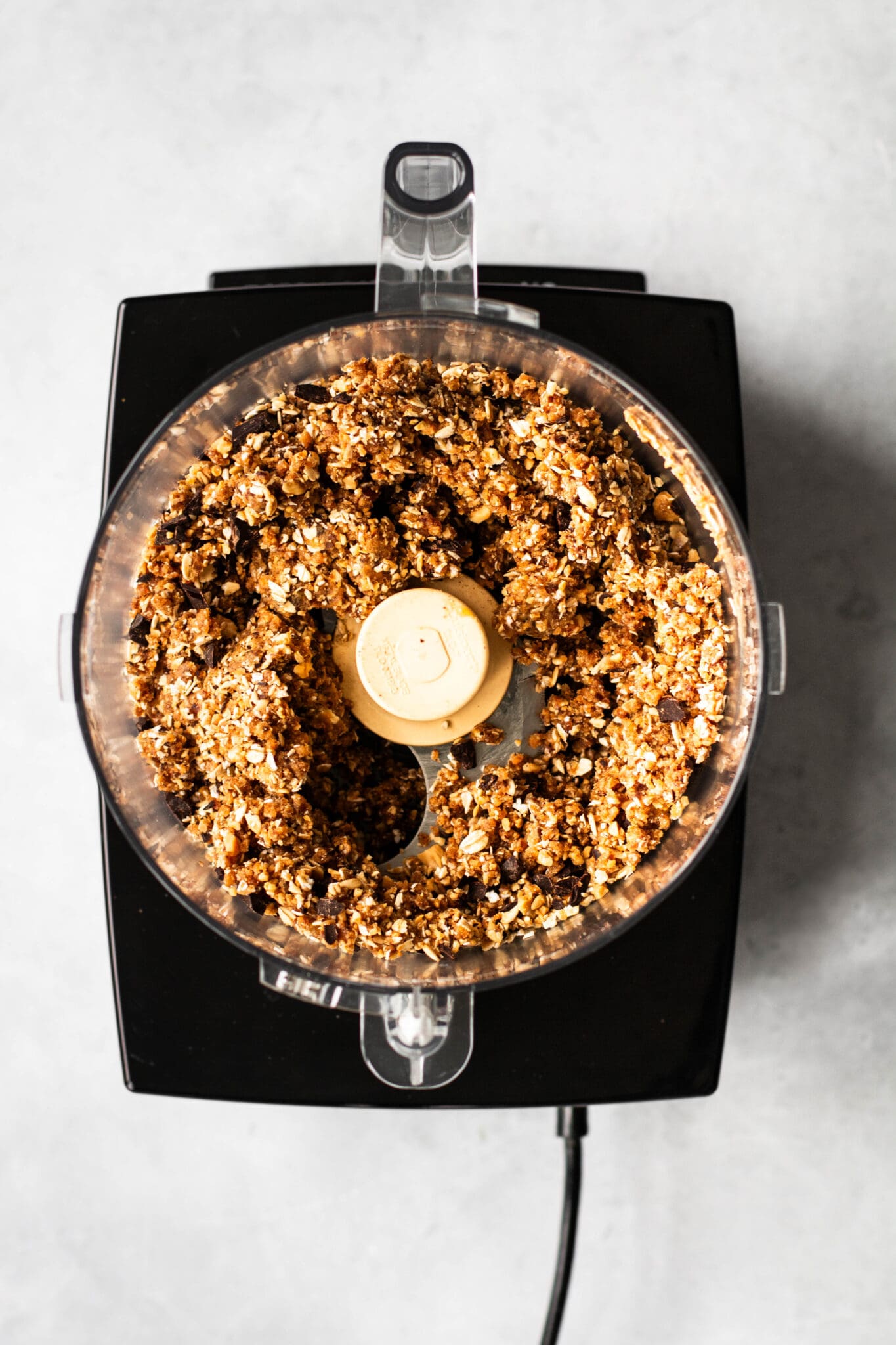 Cookie dough mixture in a food processor, seen from the top.