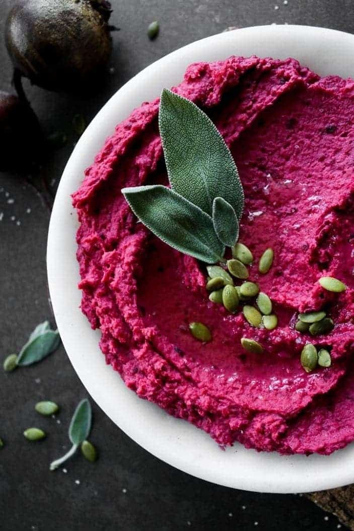 Creamy Roasted Beet Hummus with sage and pumpkin seeds on top