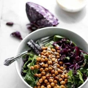 Everyday Salad with Tahini Dressing & Chickpea Croutons in a bowl with a spoon