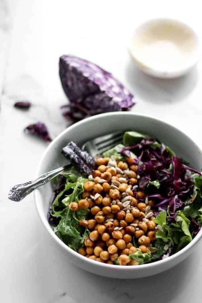 Everyday Salad with Tahini Dressing & Chickpea Croutons in a bowl with a spoon