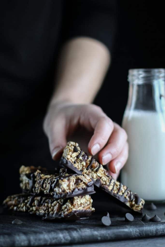 Unsweetened Caroline taking a Pretzel Chocolate Quinoa Bar seen from the side