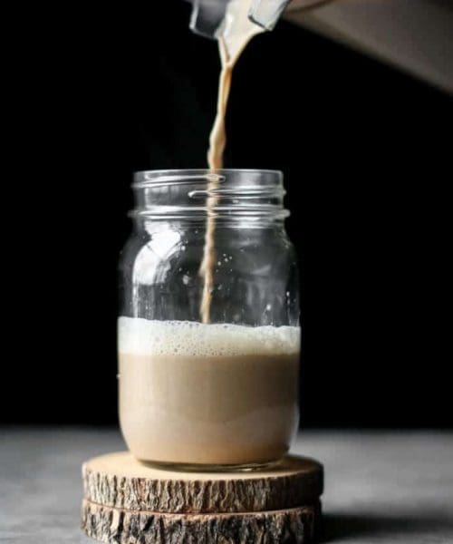 cashew dirty chai latte poured in a mason jar