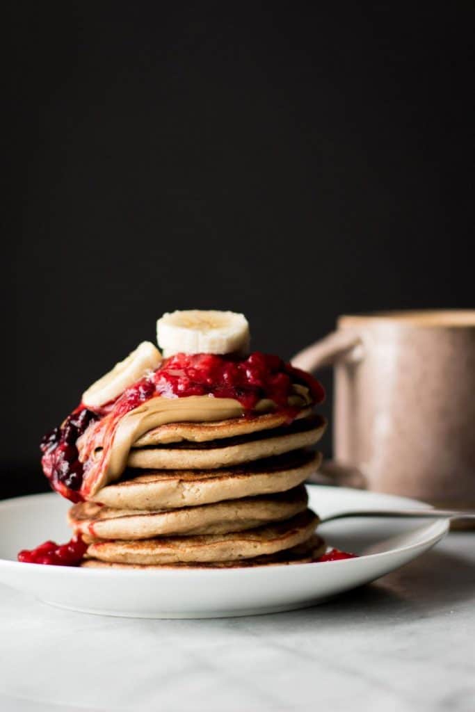 pancake stack with berries and banana slices