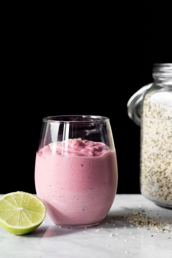 Pink Berry Lime Smoothie in a glass from the side