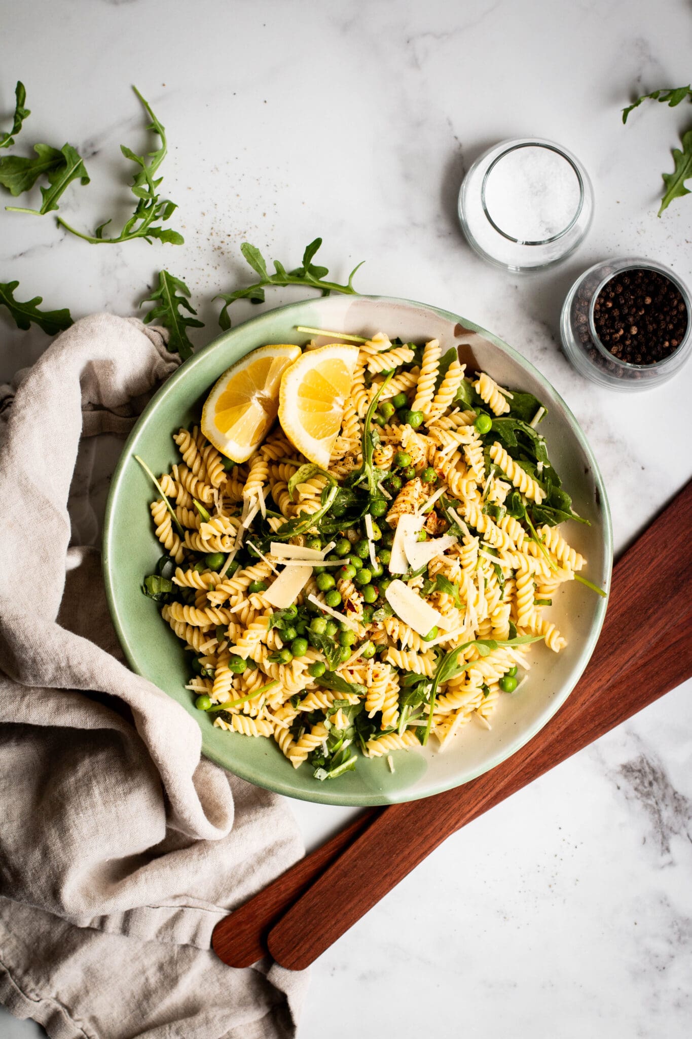Spring pea and arugula pasta salad in a bowl seen from the top.