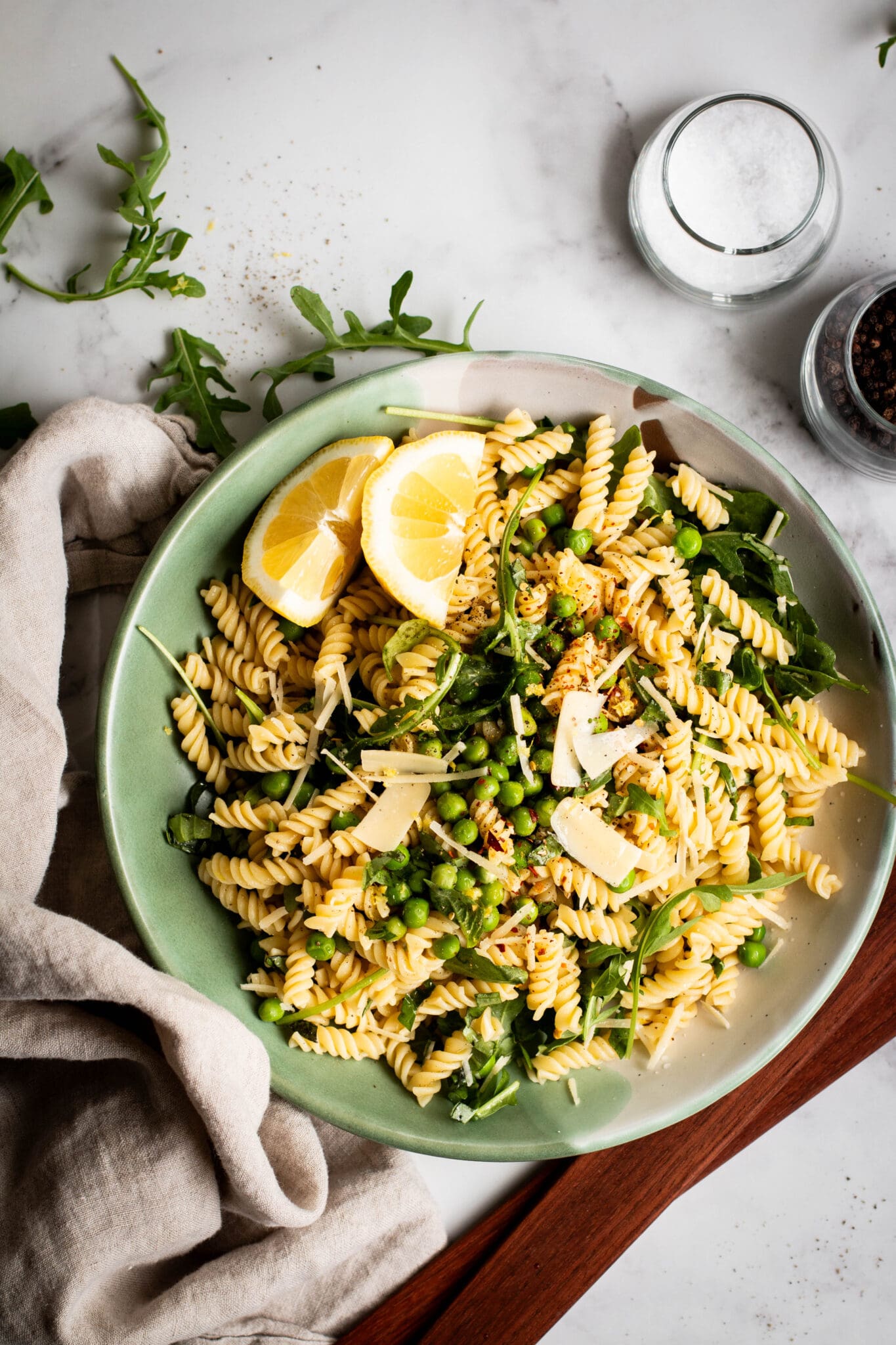 Spring pea and arugula pasta salad in a bowl seen from the top.