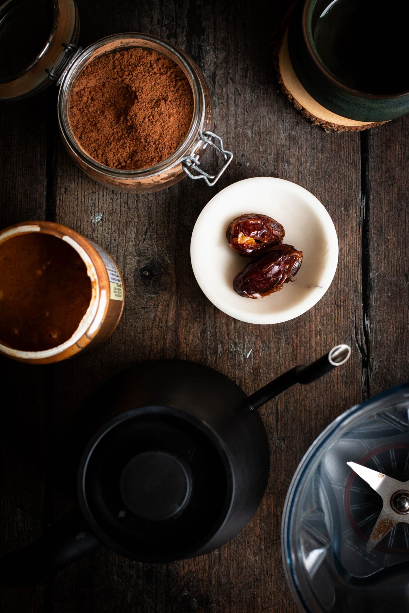 dates, cocoa, almond butter, blender and a tea kettle seen from the top