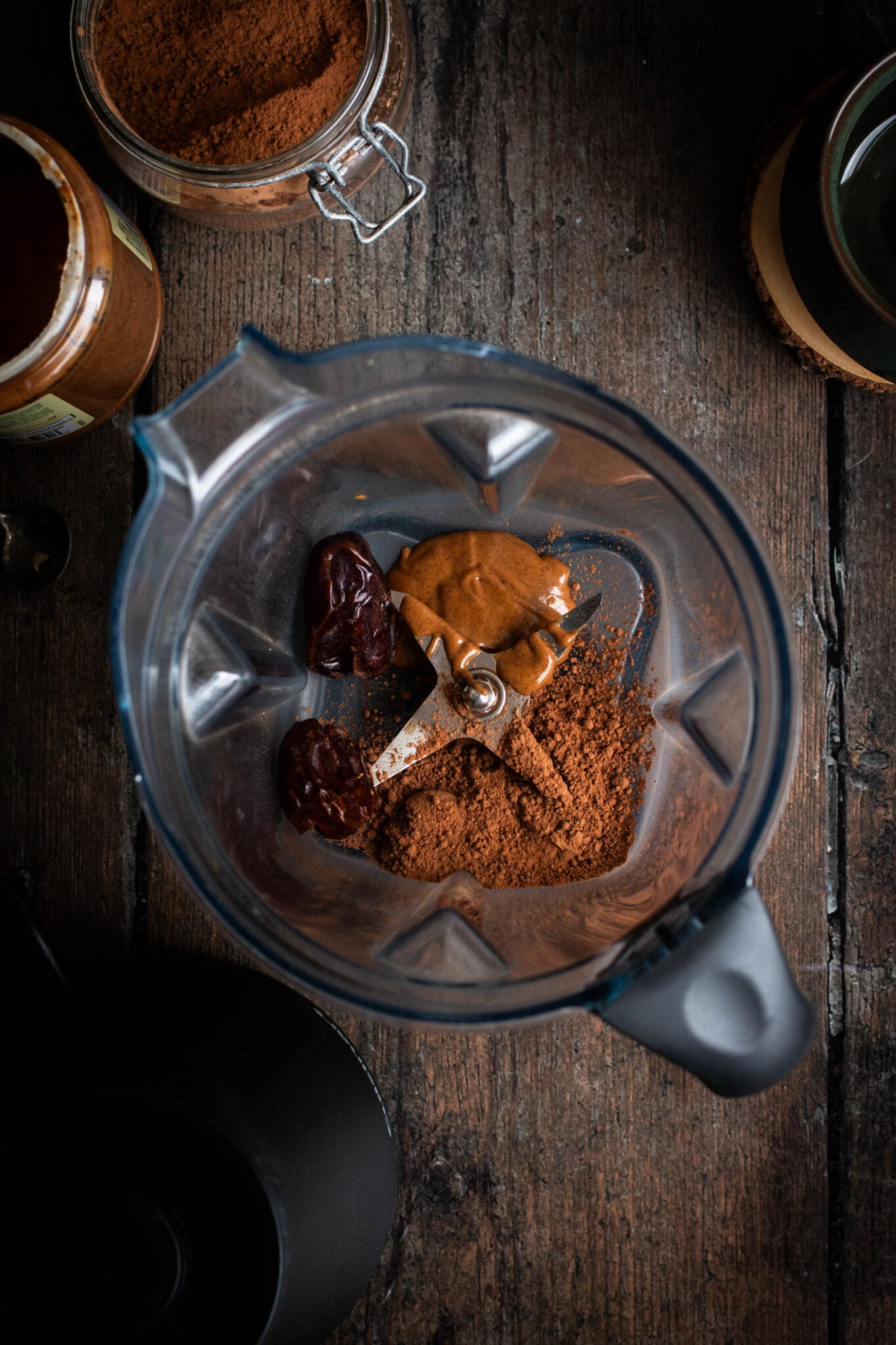 almond butter, dates and cocoa powder in a blender, seen from the top