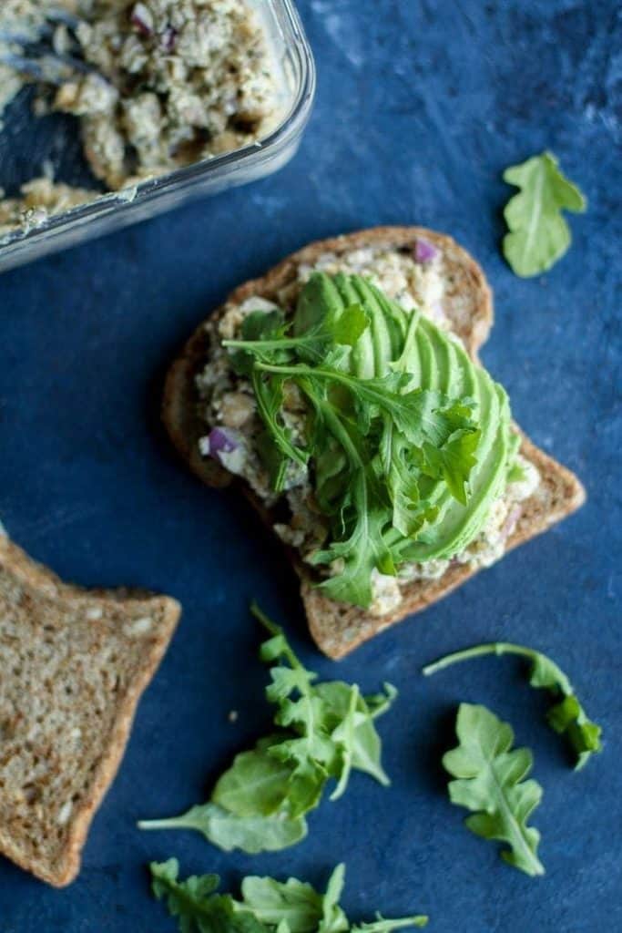 open face chickpea salad sandwich with greens 