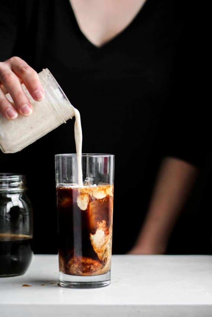 creamer poured in a vanilla coconut iced coffee