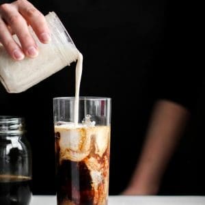 creamer poured in a vanilla coconut iced coffee