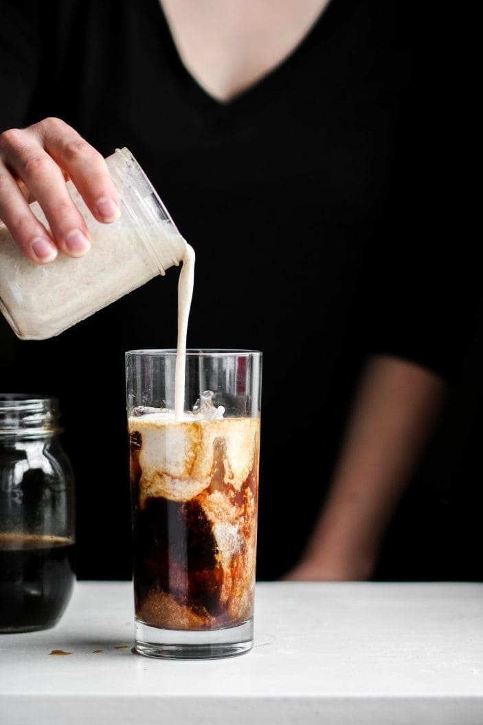 creamer poured in a vanilla coconut iced coffee