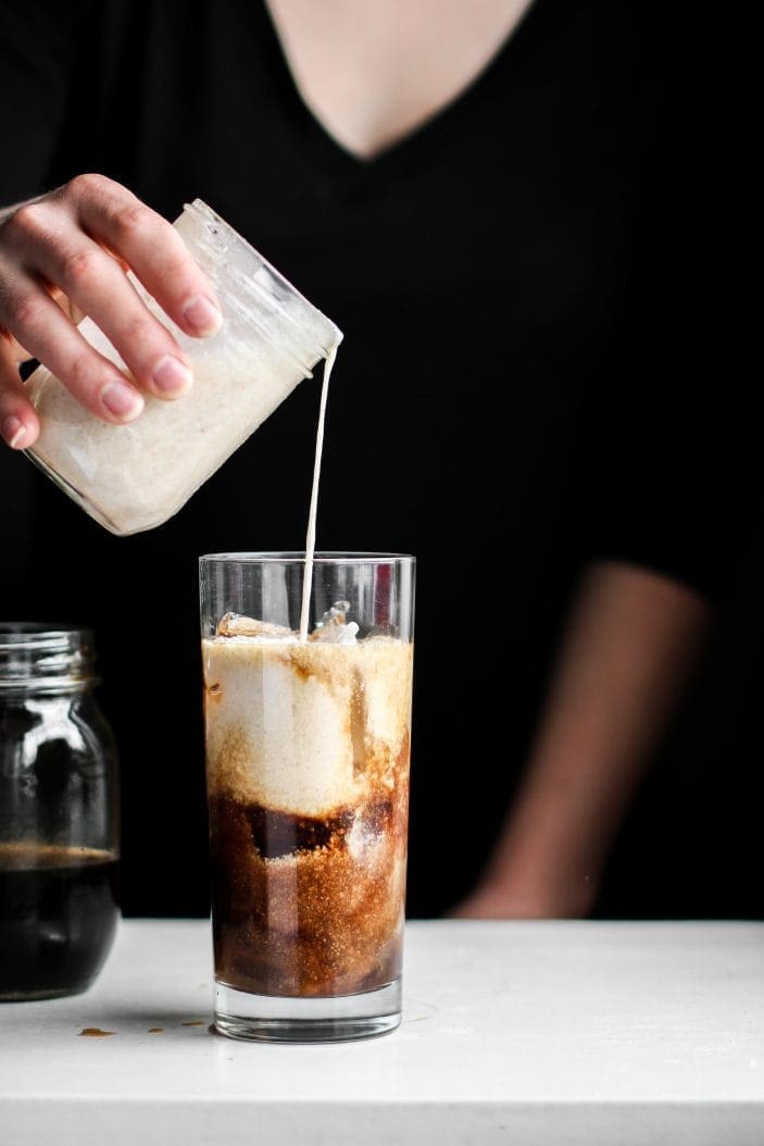 creamer poured in a vanilla coconut iced coffee