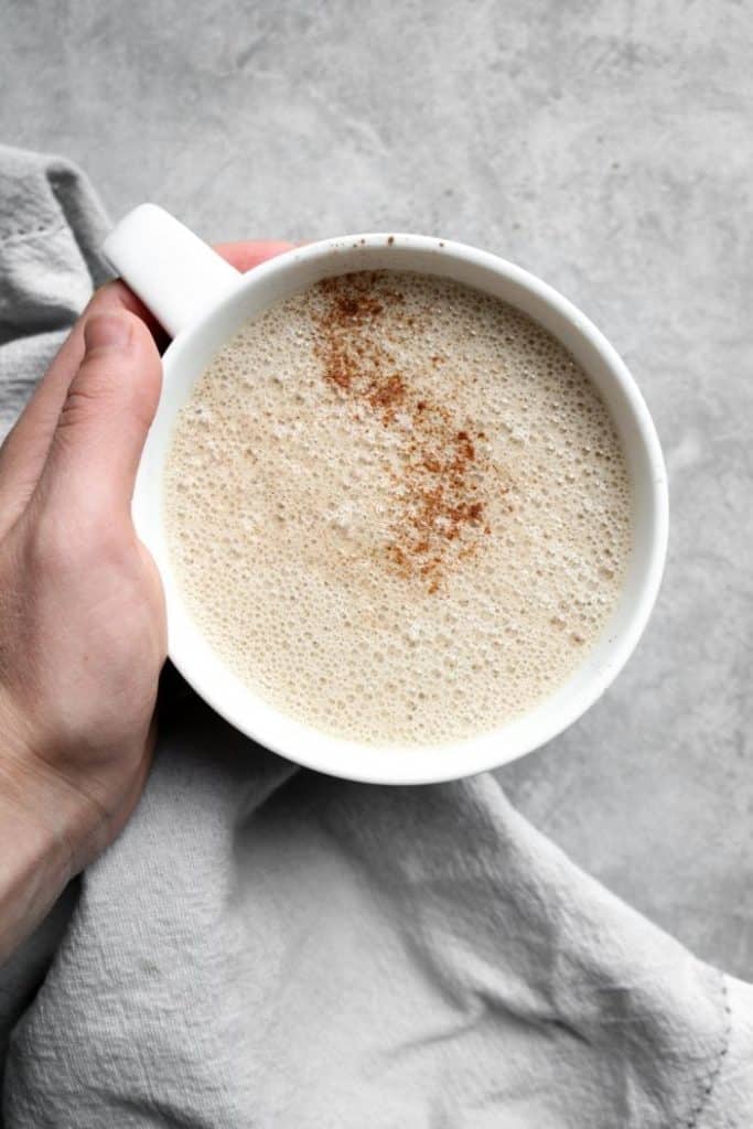 hand holding a cup of chai latte