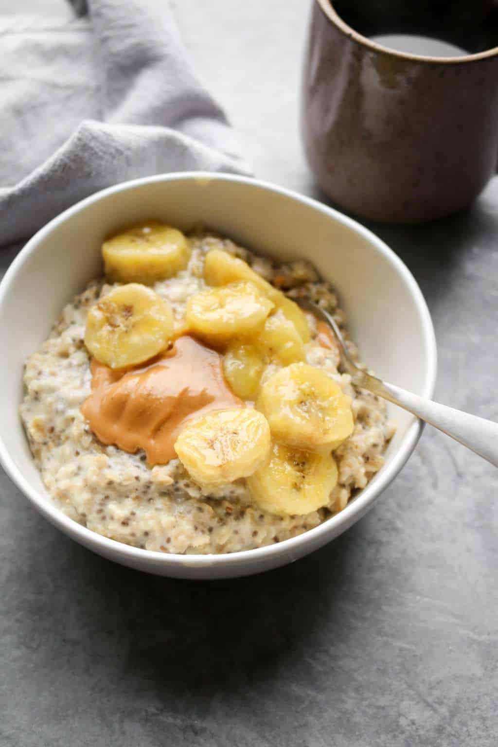 Caramelized banana oatmeal in a bowl with coffee
