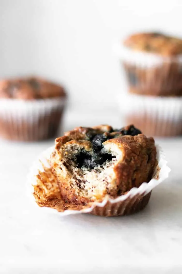 blueberry banana almond flour muffins with bite taken from it