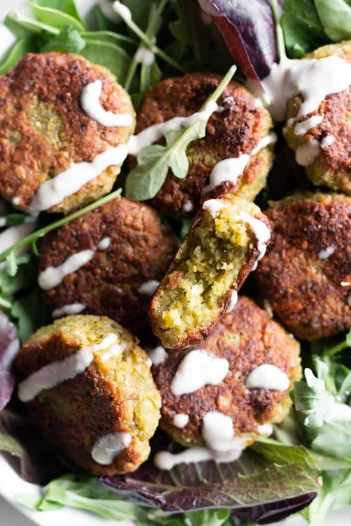 Basic Falafels closeup in a bowl of greens with sauce