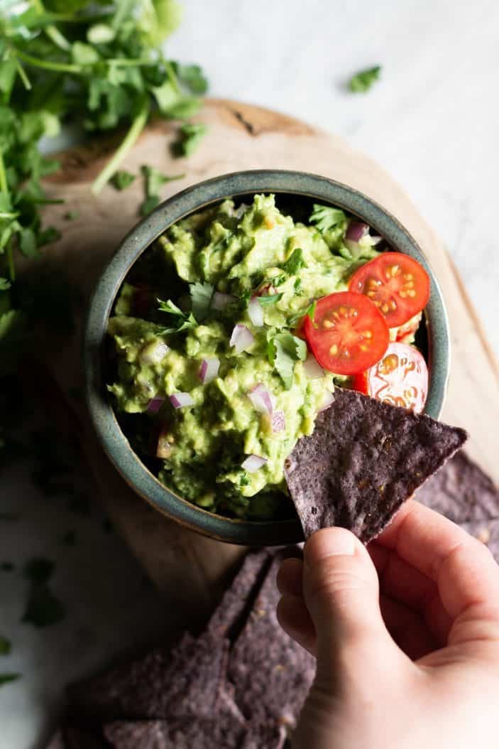 chip dipped into fresh herb guacamole