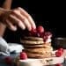 pile of buckwheat pancakes with berry compote