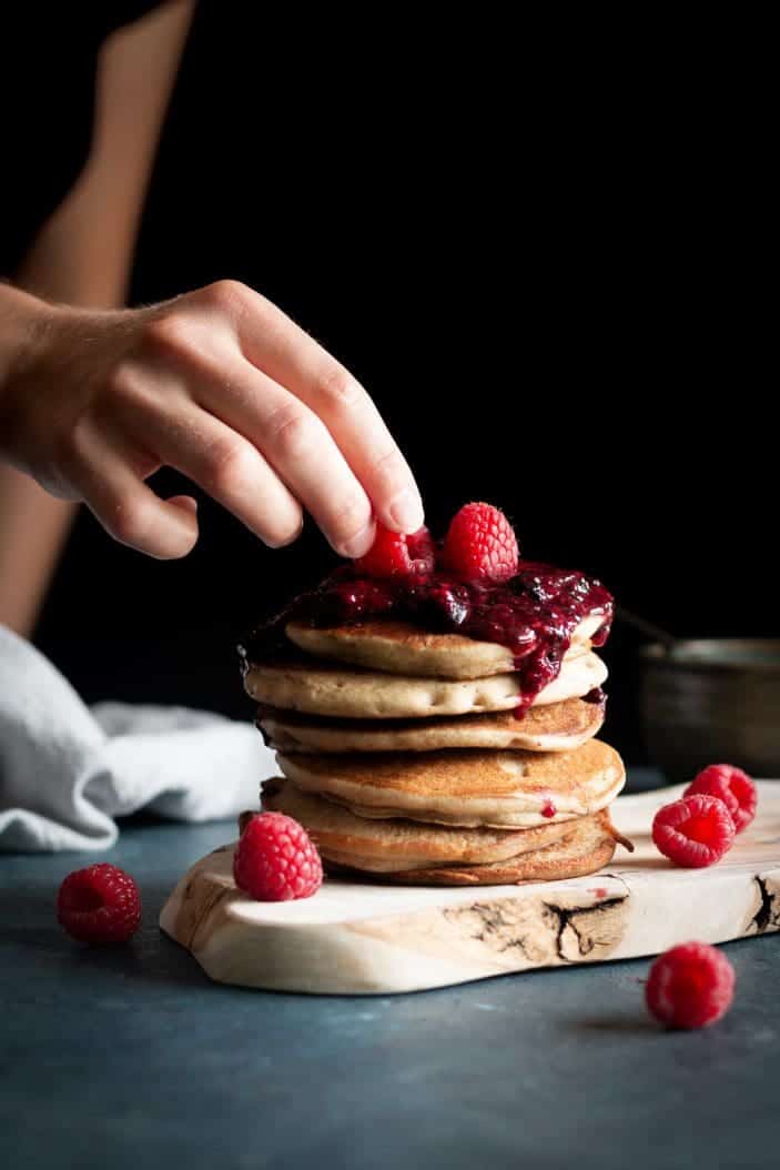 pile of buckwheat pancakes with berry compote