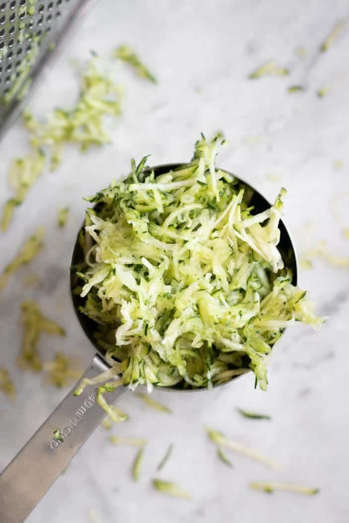 shredded zucchini in a measuring cup