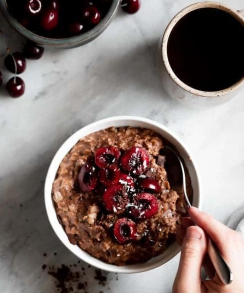 chocolate oatmeal in bowl with cherries