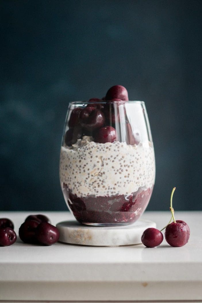 cherry overnight oats in a glass with cherries on the side