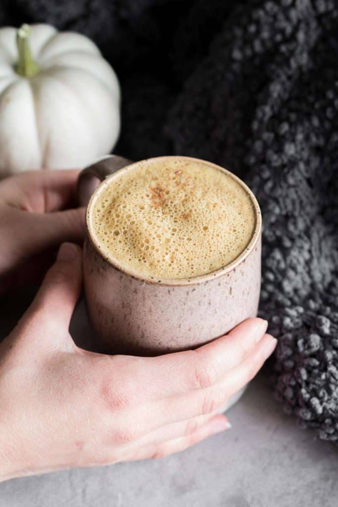 hands holding mug of pumpkin spice latte