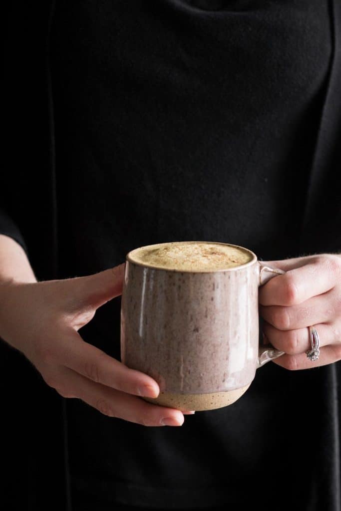 hands holding mug of latte