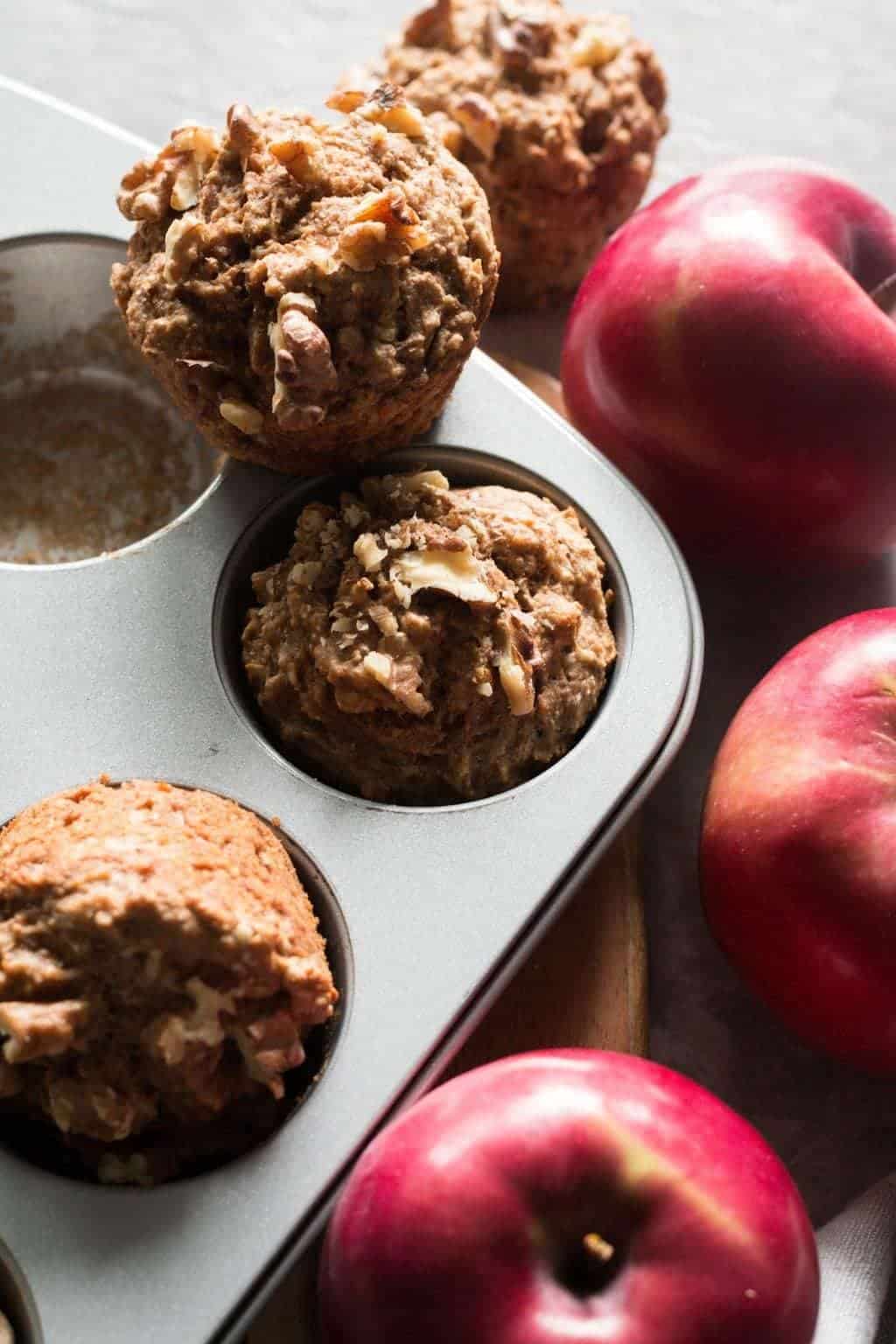 apple muffins in a muffin tin with apples