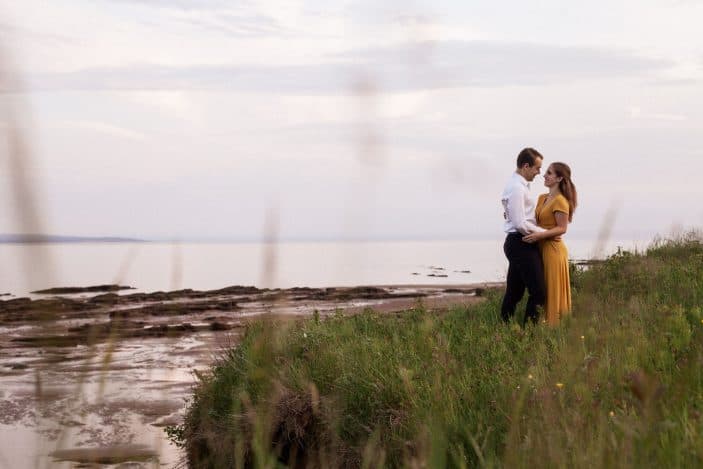 couple holding each other in tall grass