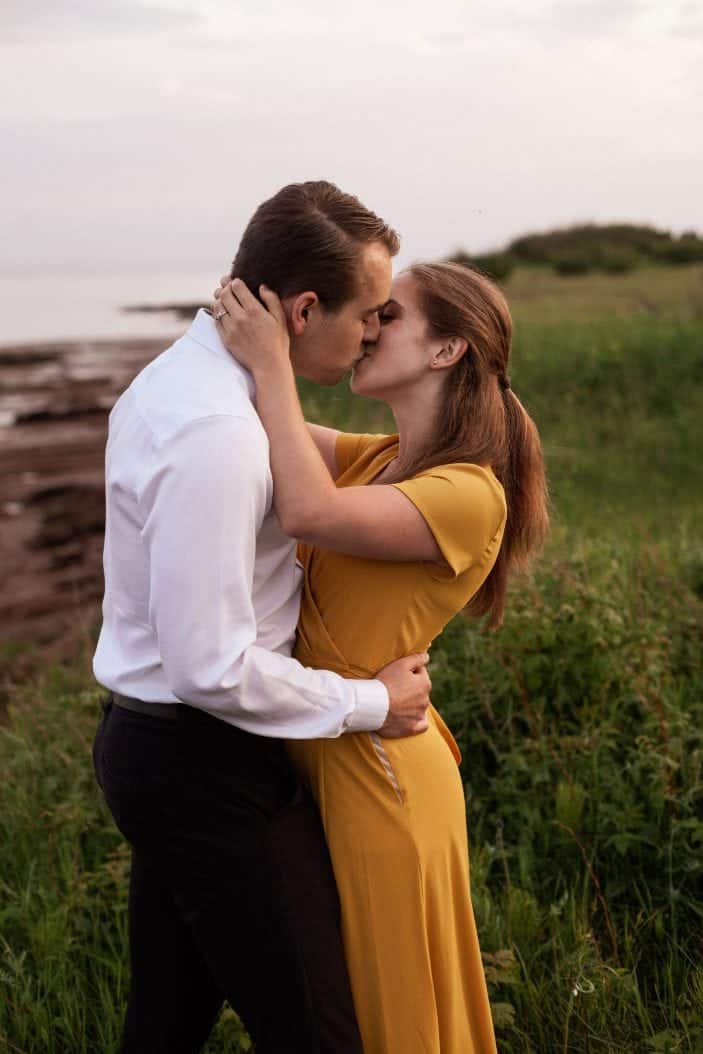 couple kissing in tall grass