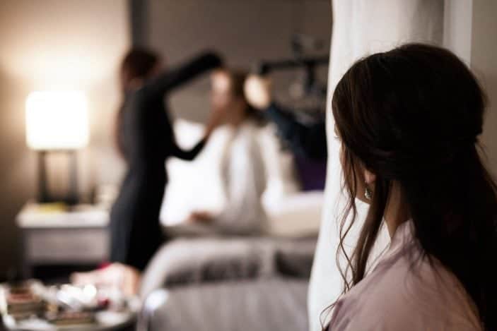 bridesmaid looking at brie getting makeup done