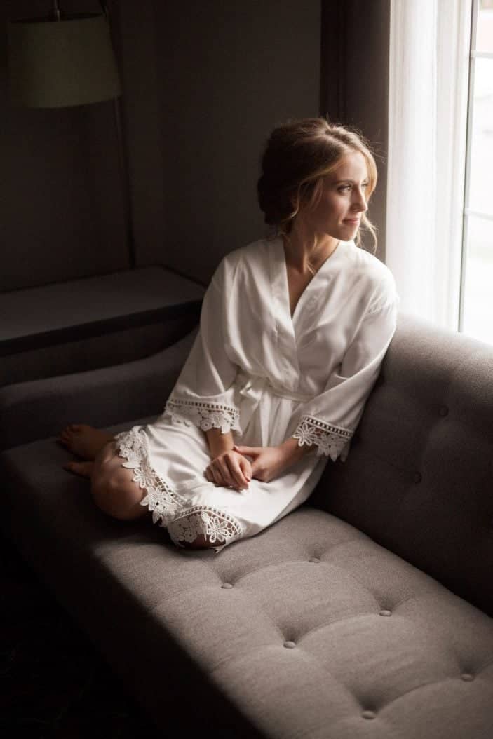 bride sitting on sofa with robe