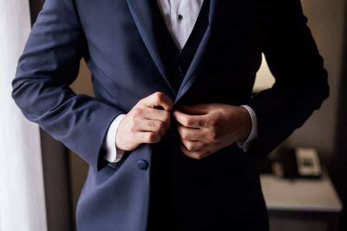 groom buttoning tux