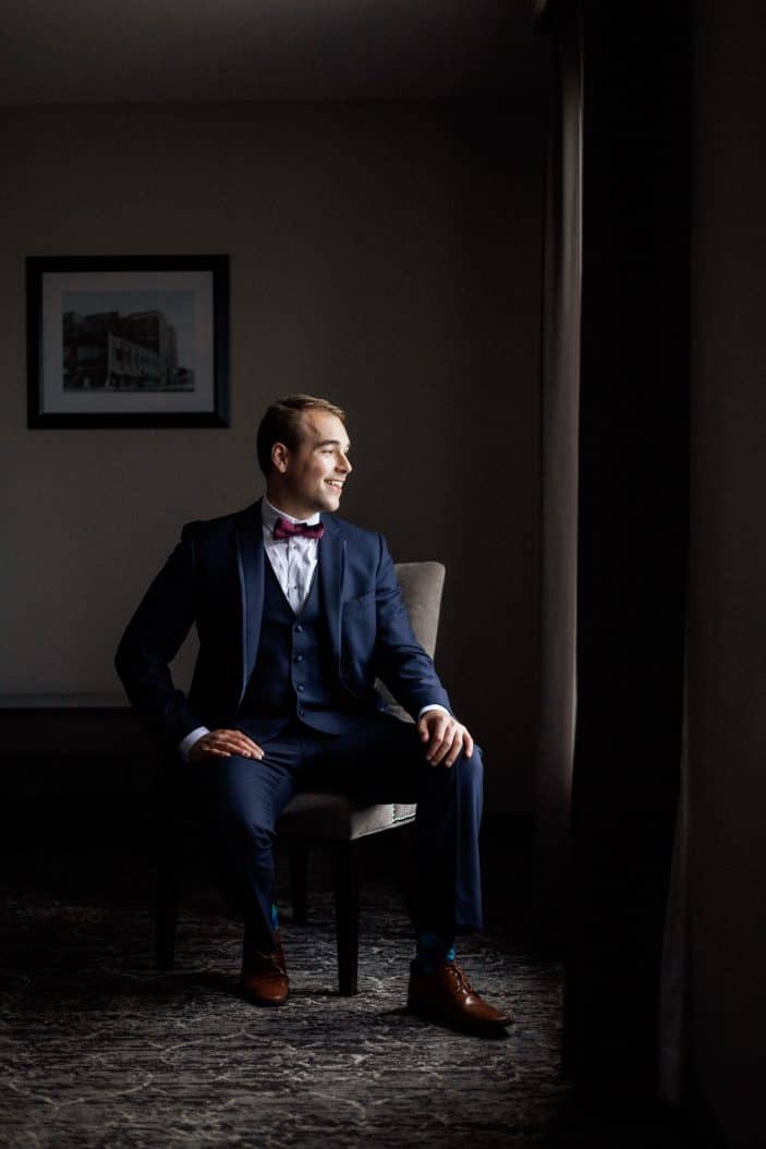 groom sitting, looking out window