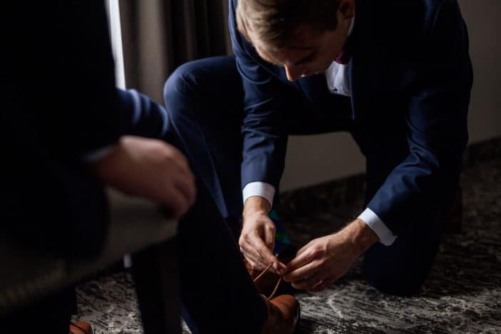 groom lacing brother's shoes