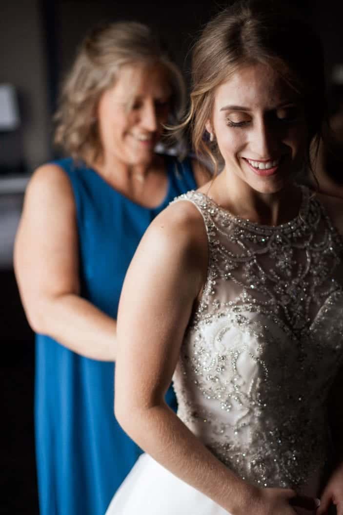 mother of the bride helping with dress