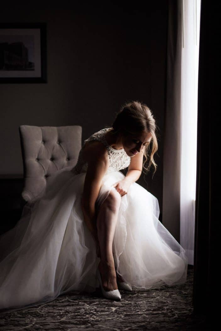 bride in dress, putting on shoes