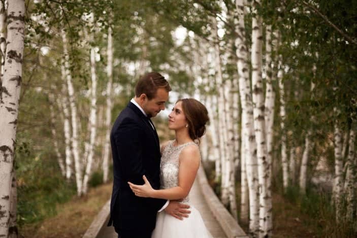 bride and groom looking at each other in forest - cozy fall wedding