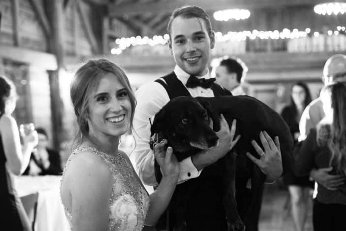 bride and groom holding dog