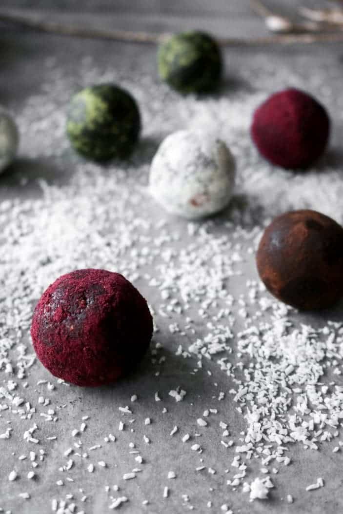 Seven Easy Holiday Truffles seen from the side in different colours ranging from red, brown, white and green.