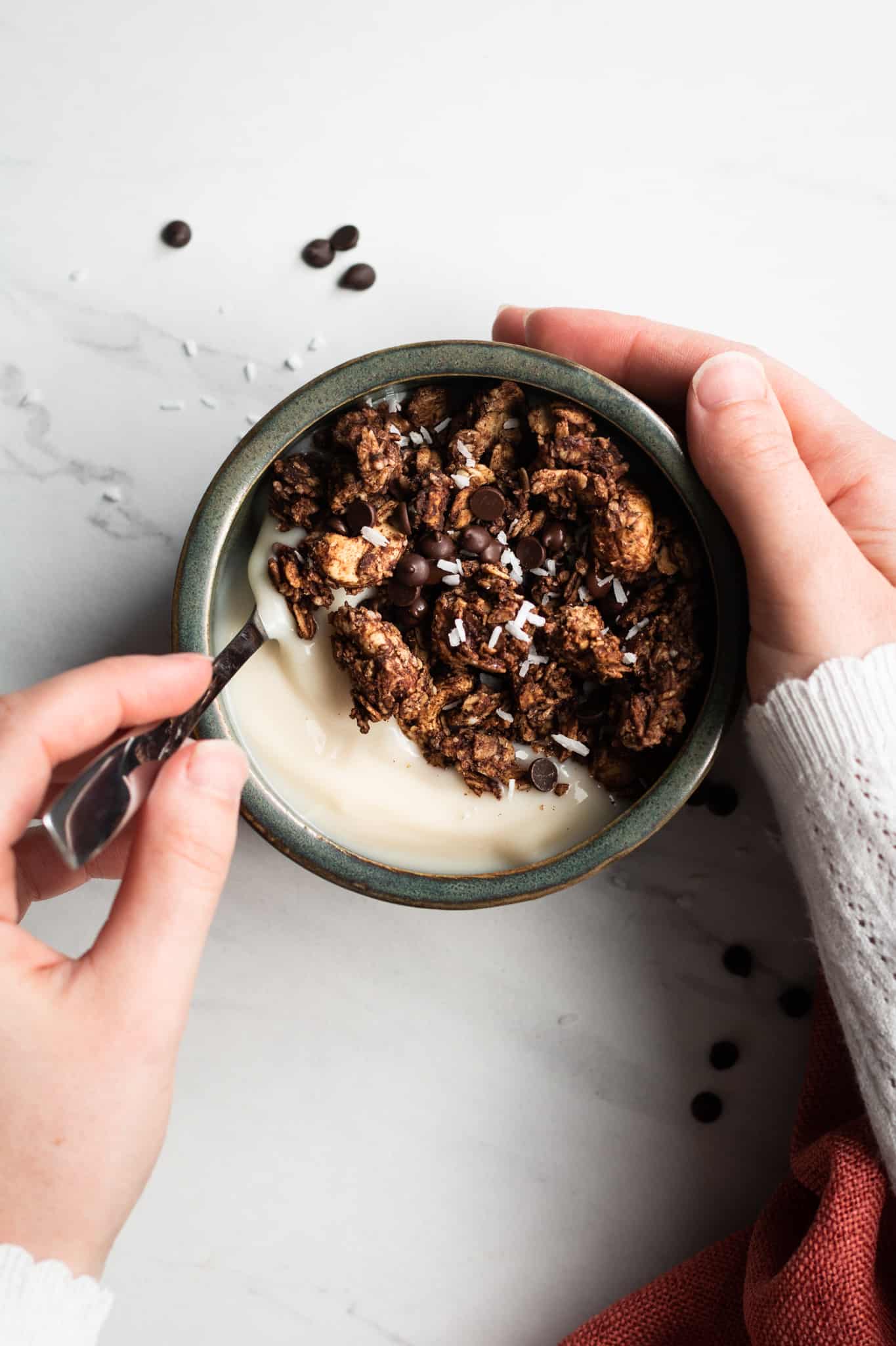 hand holding a bowl of granola with yogurt