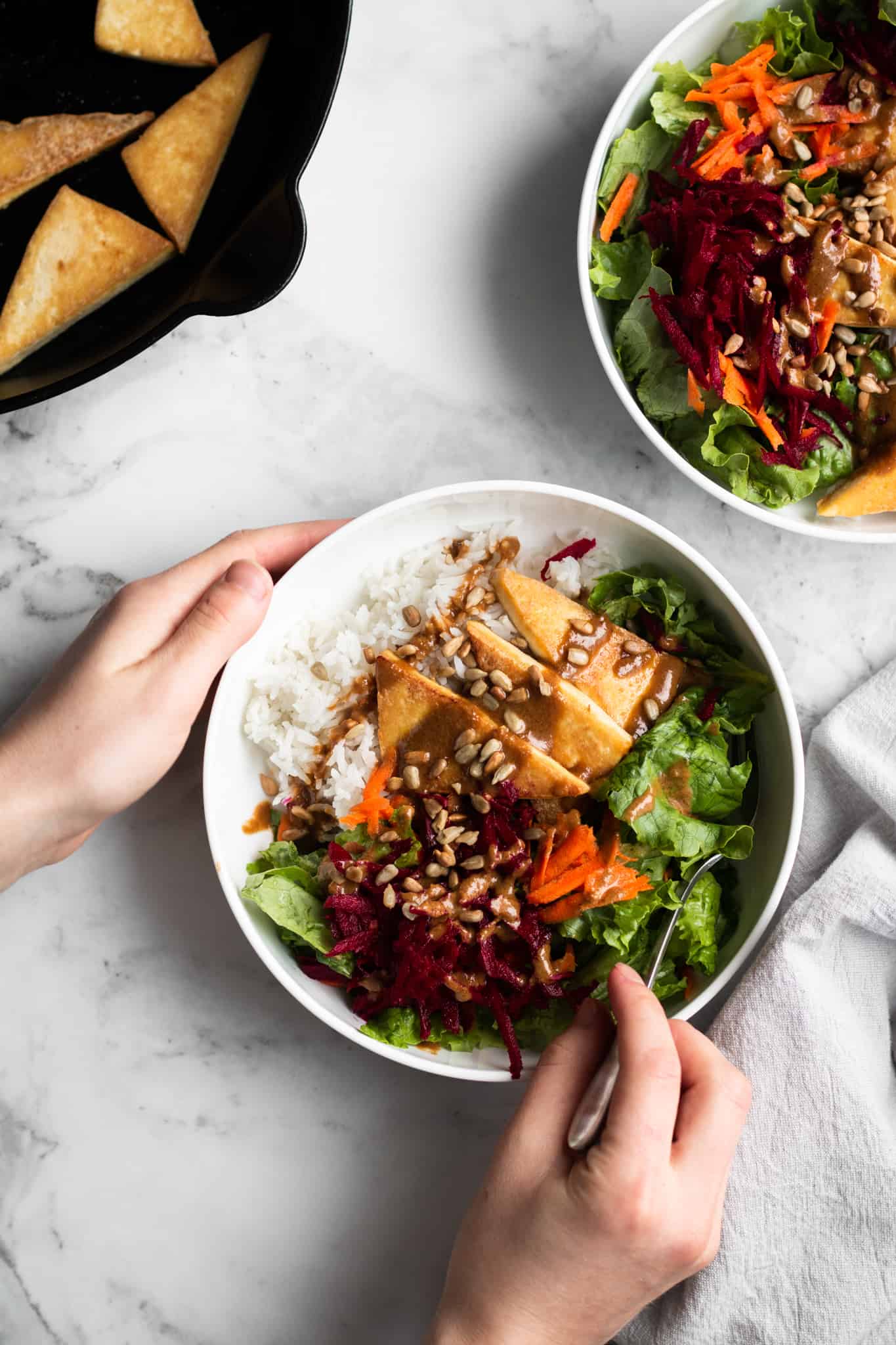 hands holding a bowl of salad