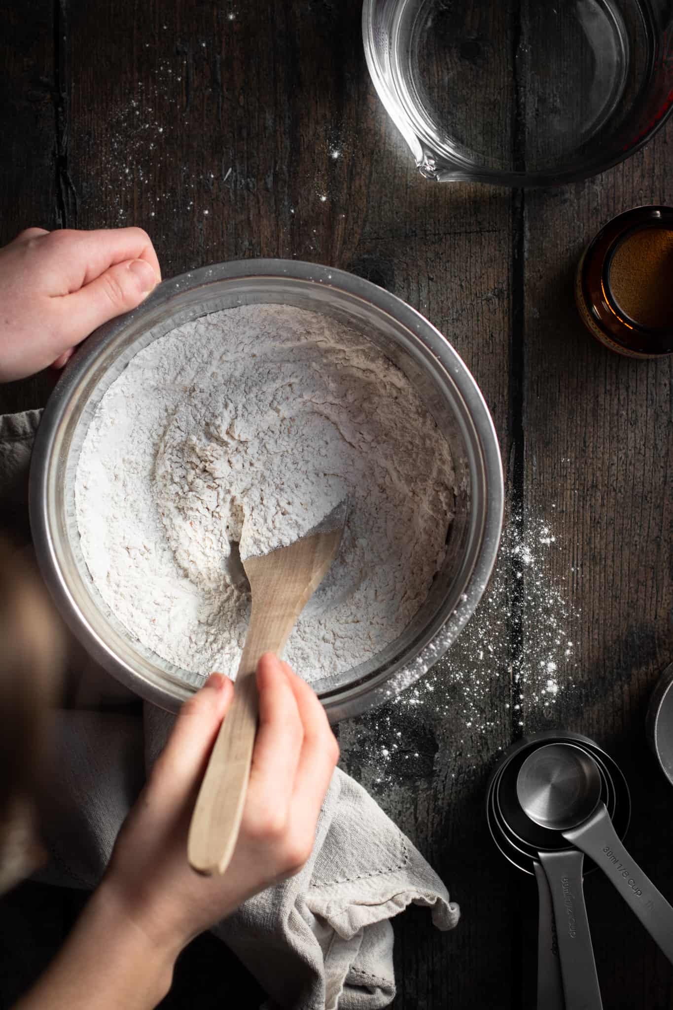 hand stirring flour in a bowl