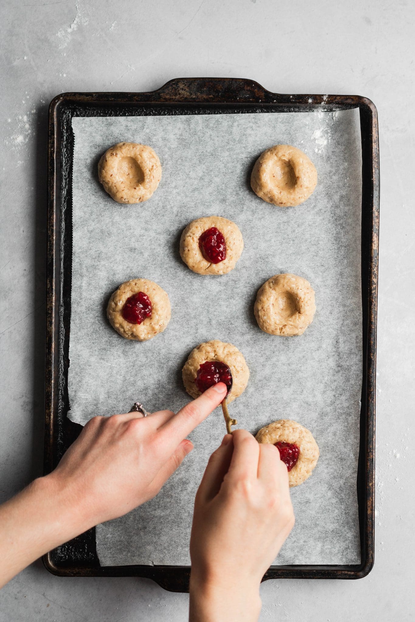 cookie dough on a baking sheet with jam