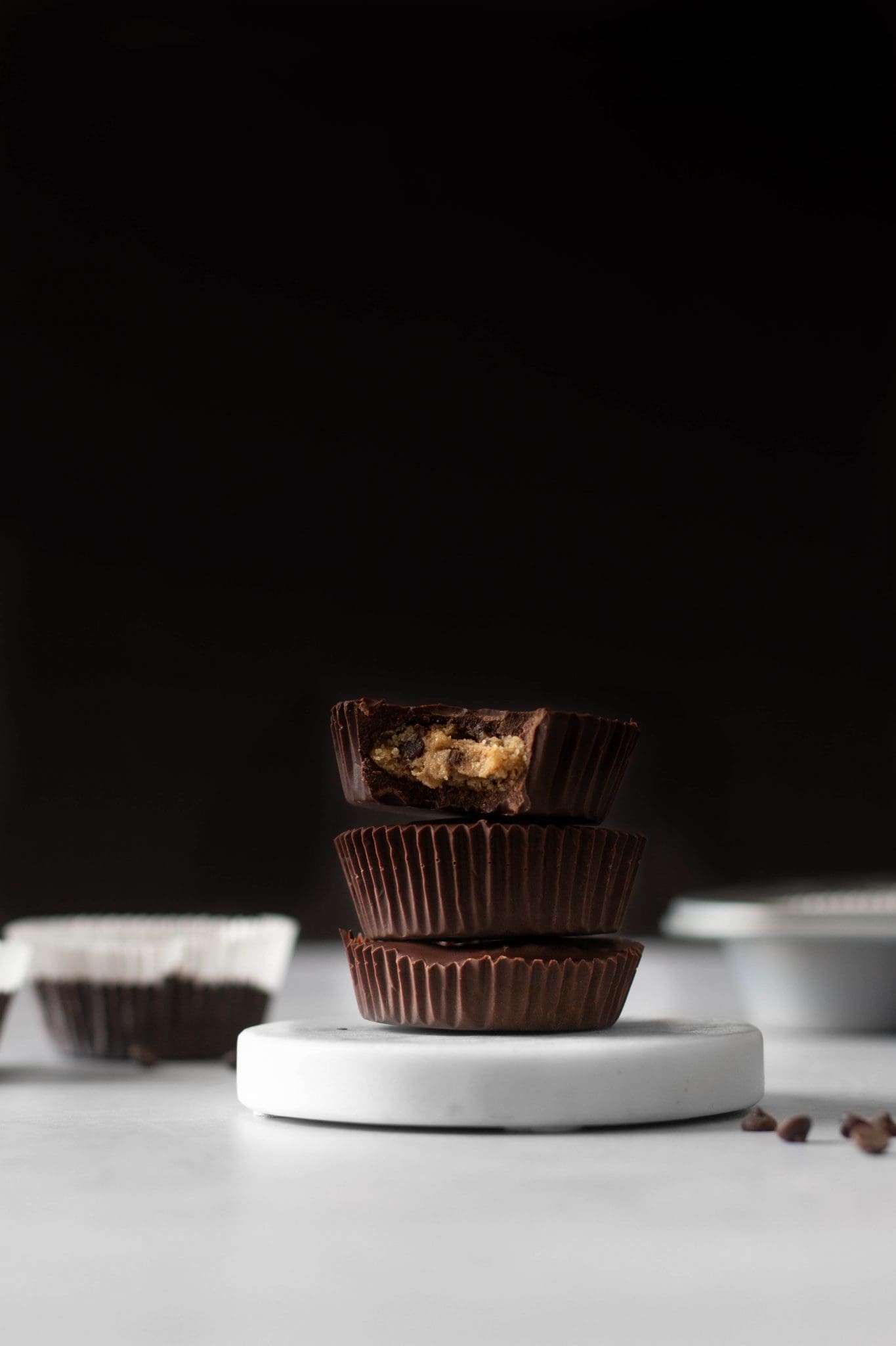 stack of vegan cookie dough chocolate cups with bite taken