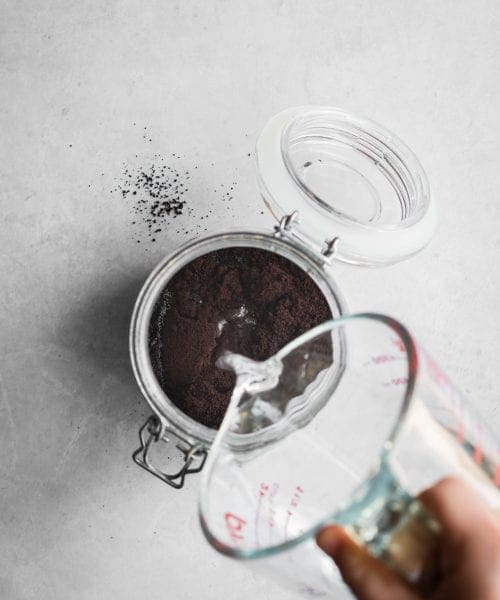 how to make cold brew coffee - water poured over coffee grounds