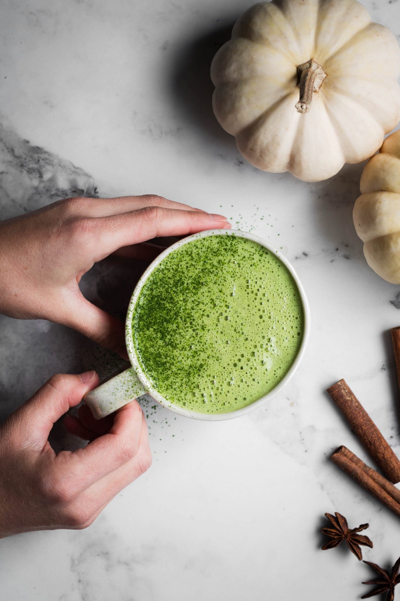 hands holding cup of matcha latte
