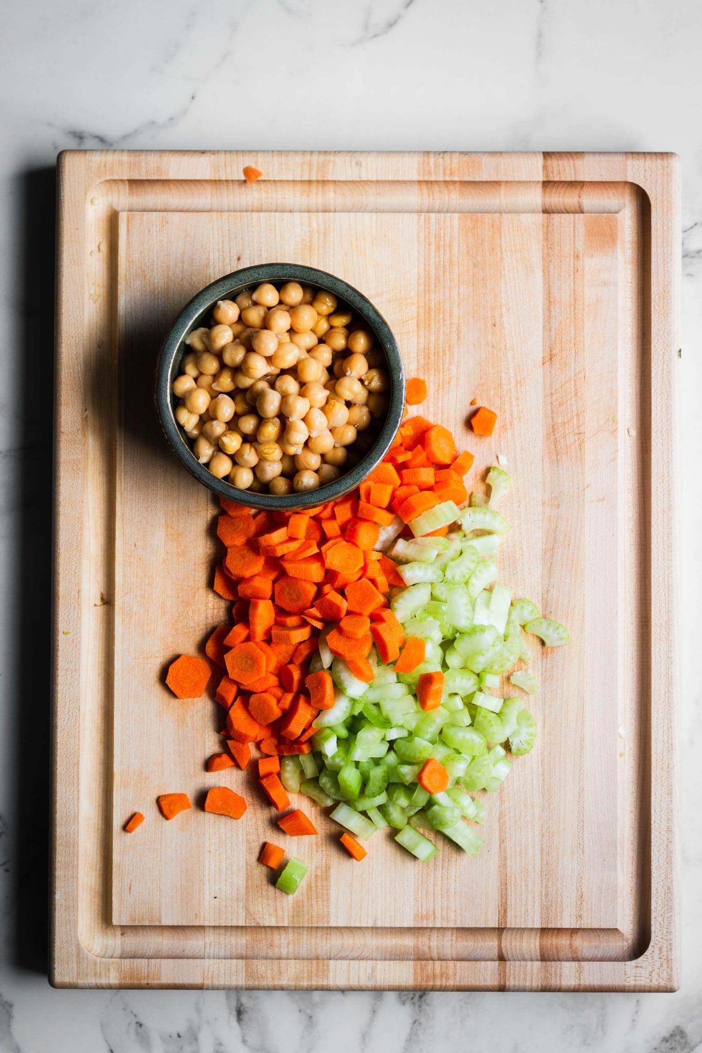 celery, carrots and chickpeas on a cutting board